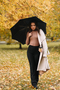 Beautiful woman standing in rain during autumn