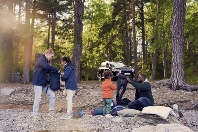 Family preparing for camping against trees