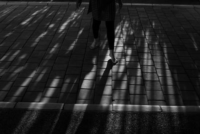 Low section of woman walking on sidewalk