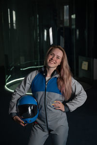 Portrait of smiling young woman standing in car