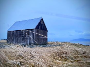 Barn on field against sky