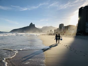 People on beach against sky