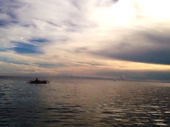 Boats in sea at sunset