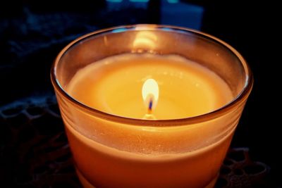 Close-up of lit tea light candle on table