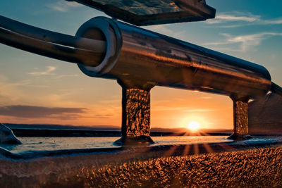 Built structure on beach against sky during sunset