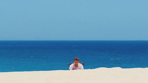 Woman on beach against clear sky