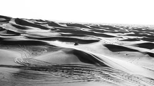 Close-up of sand dune on beach against clear sky