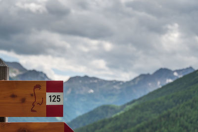 Sign on mountain against sky