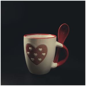 Close-up of coffee cup on table against black background