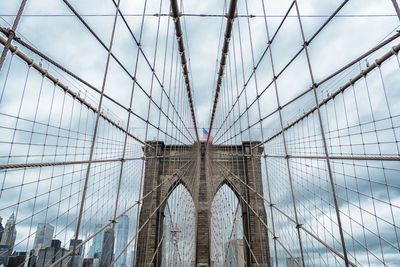 Low angle view of brooklyn bridge against cloudy sky