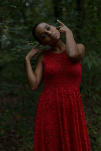 Portrait of young woman standing against red rock