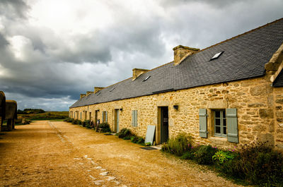 Houses by building against sky