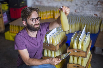 Man checking stock of juice bottles in warehouse