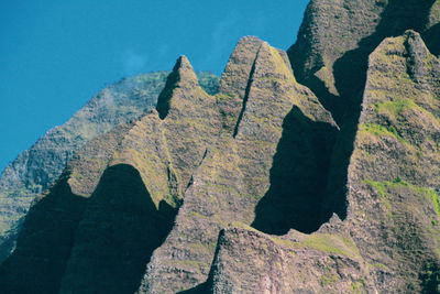 Low angle view of rocks on mountain against sky