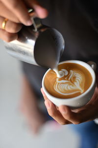 Close-up of hand making latte