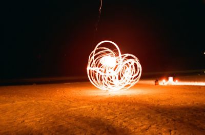 Illuminated light painting against dark sky