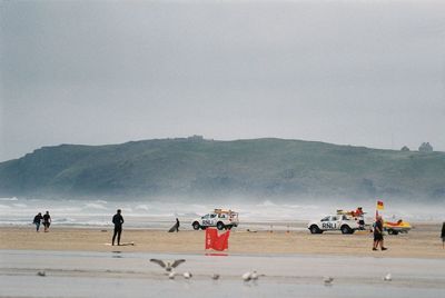 People enjoying in sea against sky