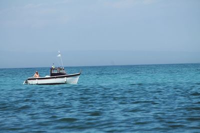 Boat sailing in sea against clear sky