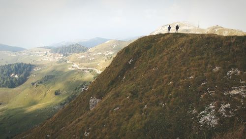 Distant view of people standing on mountain