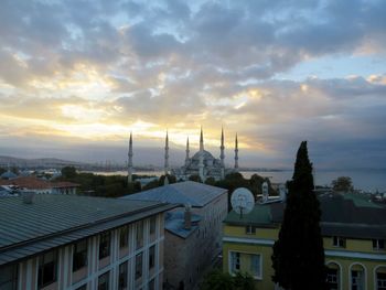 High angle view of cityscape against cloudy sky during sunset