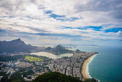 Aerial view of cityscape against cloudy sky