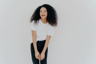 Portrait of smiling woman standing against white background