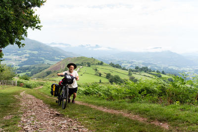 Rear view of man riding bicycle on mountain