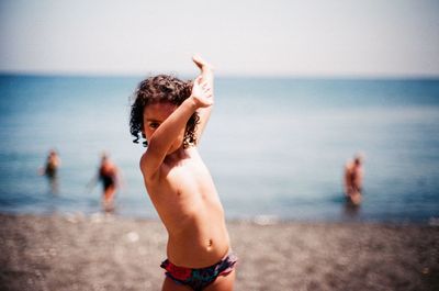 Full length of shirtless boy on beach