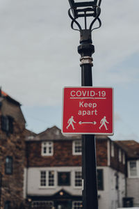 Low angle view of information sign against buildings in city