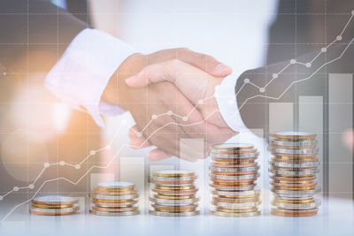 Digital composite image of hand holding coins