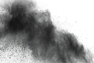 Defocused image of black powder paints against white background