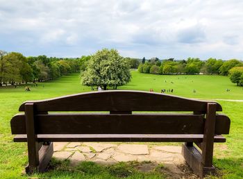 Bench in park against sky