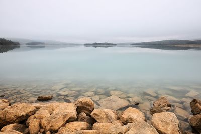 Scenic view of rocks in sea against sky