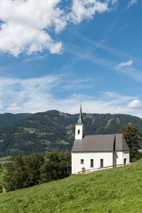 Built structure on landscape by buildings against sky
