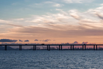 Pier over sea against sky during sunset