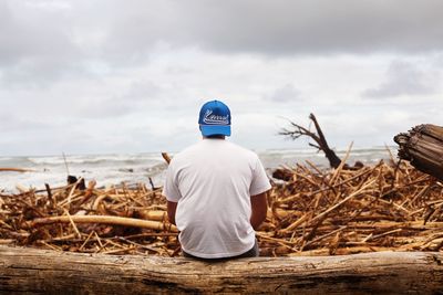 Rear view of man sitting on beach