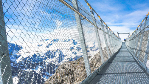 Empty titlis cliff walk by mountains against sky