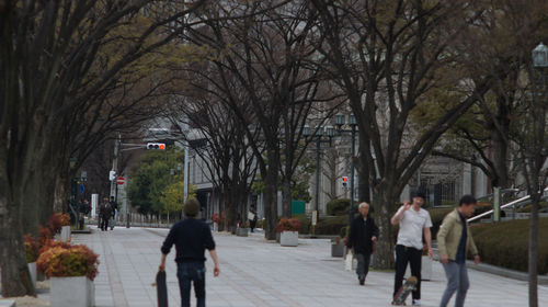 People walking on sidewalk in city during winter