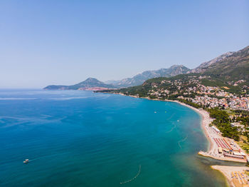 Scenic view of sea and mountains against clear sky