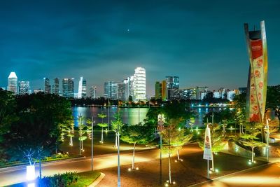 Illuminated buildings in city against sky at night