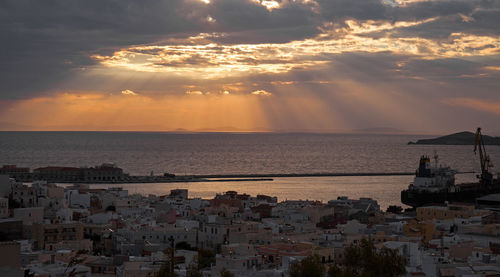 Rays of light beam down over the port of ermoupoli, syros, greece