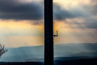 Silhouette crane against sky during sunset