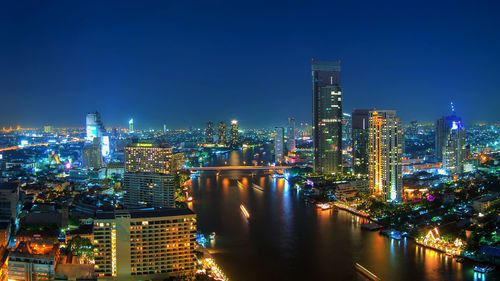 Illuminated buildings in city against sky at night