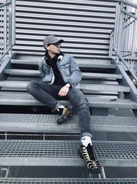 Full length of young man sitting on staircase