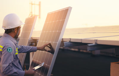 Engineer solar photovoltaic panels station checks with tablet computer. energy technology concept