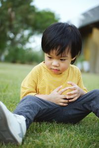 Portrait of boy sitting on field