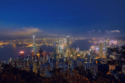 High angle view of illuminated buildings against sky at night