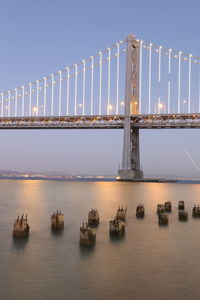 Low angle view of illuminated bay bridge over san francisco bay at dusk