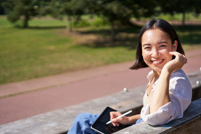 Portrait of young woman sitting on bench