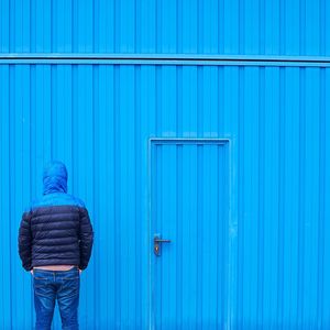 Rear view of woman standing against blue sky